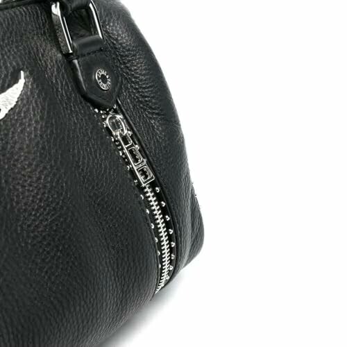 Close-up of a black leather handbag with a zipper