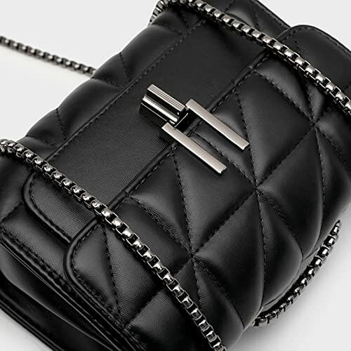 Close-up of a black quilted leather handbag with metallic chain strap.