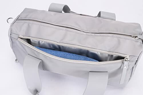 Gray duffel bag with open zip pocket showing blue fabric inside.