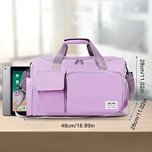 Purple gym bag with front pockets and iPad for size reference.