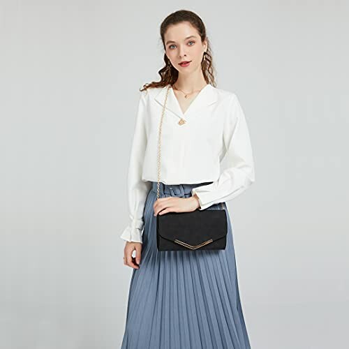 Woman in white blouse and blue skirt holding a black handbag