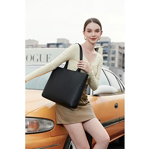 Woman leaning on car holding a black tote bag